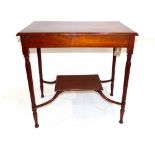 An Edwardian mahogany two tier side table, with tapering reed legs, shaped stretchers with open
