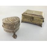 A white metal music box, engraved with floral design, raised on three leaf feet, H. 9cm, together