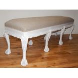 A Victorian style white painted window seat, with natural linen upholstery, on six carved cabriole