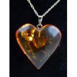 10ct yellow gold amber heart pendant, suspended on a 9ct yellow gold chain.