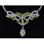 A silver, cubic zirconia and peridot pendant, with articulated chain necklace.