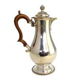 A George V silver hot water pot, Carrington & Co., London 1919, of baluster form with stained