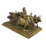 An Indian bronze and brass study of a log gatherer, sitting atop his cart pulled by two oxen. L.