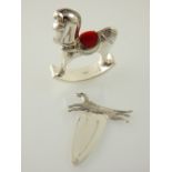 A silver rocking horse pin cushion, H. 6.5cm, together with a silver bookmark with dog finial. (2)