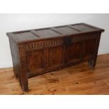 An 18th century oak coffer, with four panel hinged top and front divided by a fluted frieze, on