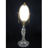 An Edwardian dressing table mirror, oval bevelled plate, brass beaded edge, with floral and bow