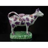 Sunderland lustre pearlware cow creamer, purple decoration, naturalistic grass base. H. 14cm