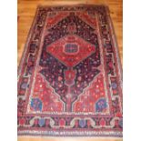 A Hamadan rug, with a lozenge in an open diamond blue and scarlet cartouche with 'Herati' frieze