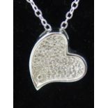 An 18ct white gold and diamond heart shaped pendant on a silver chain.