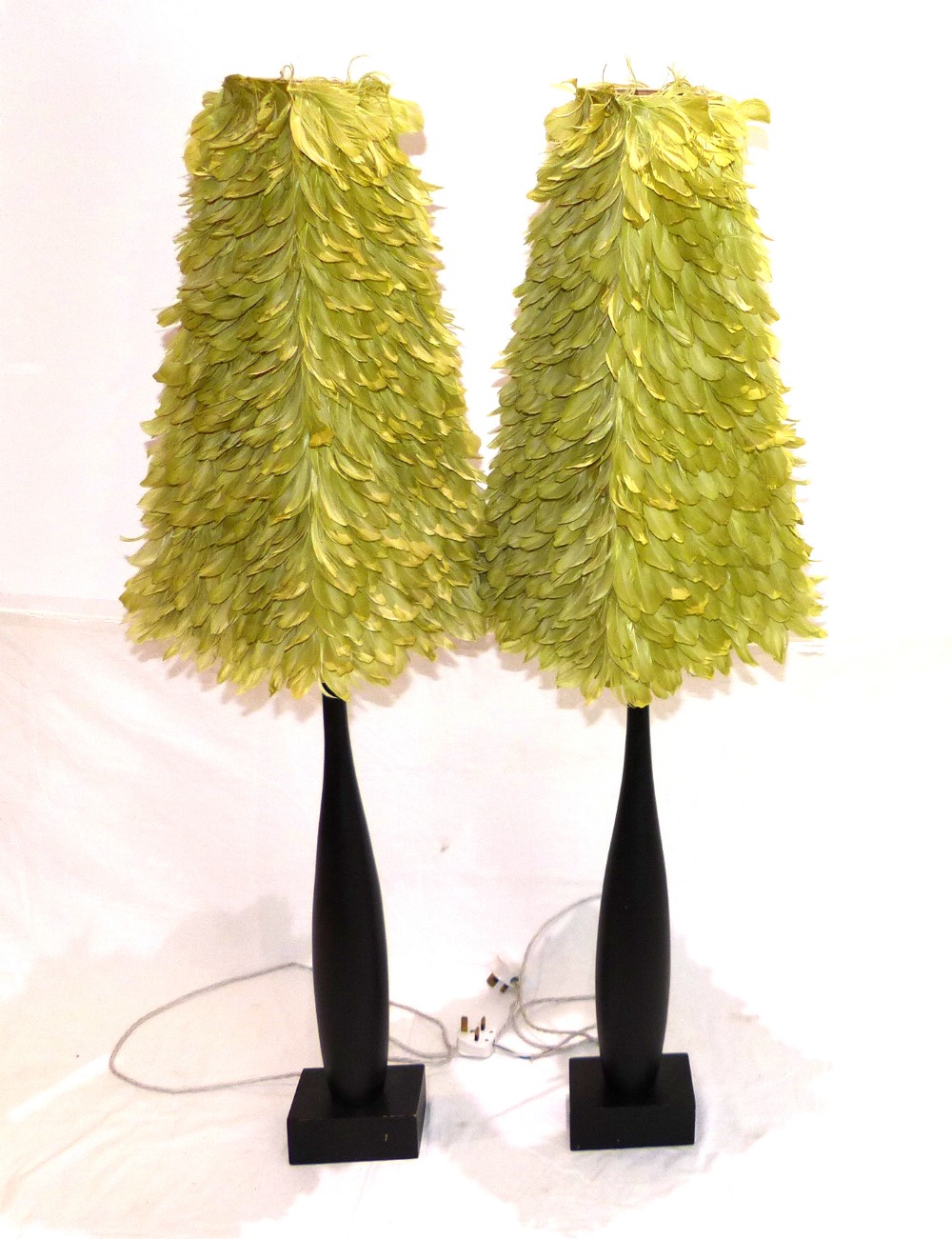 A pair of ebonised contemporary table lamps, Orla Collins, green layered feather shades. H.