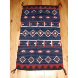 Navajo Hopi Indian handwoven rug, decorated with geometric devises on a blue / black striped ground.