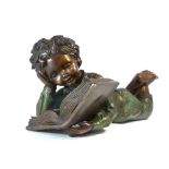 A contemporary patinated bronze of a young boy reading a book. L.