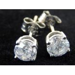 Pair of white gold and diamond solitaire ear studs, the circular stone total weight 1.