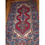 Turkish rug, geometric design, within blue ground border, fringed, 190 x 117cm