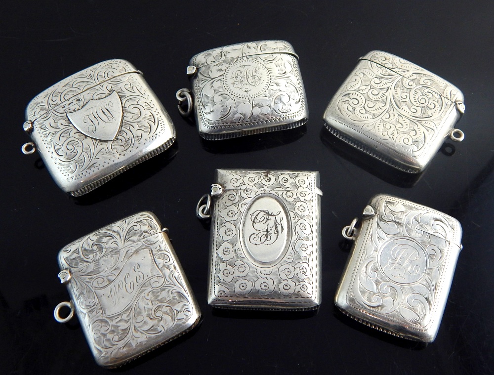 Six silver Vesta cases, all with foliate decoration and monograms,