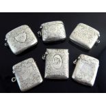 Six silver Vesta cases, all with foliate decoration and monograms,