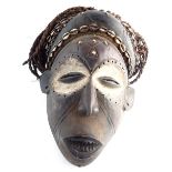 Igbo bead and cowrie shell decorated carved wooden tribal mask,