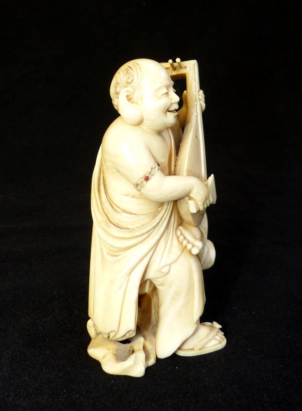 A19th C carved ivory okimono of a plump monk strumming a lute, signed in red seal to base, - Image 2 of 4