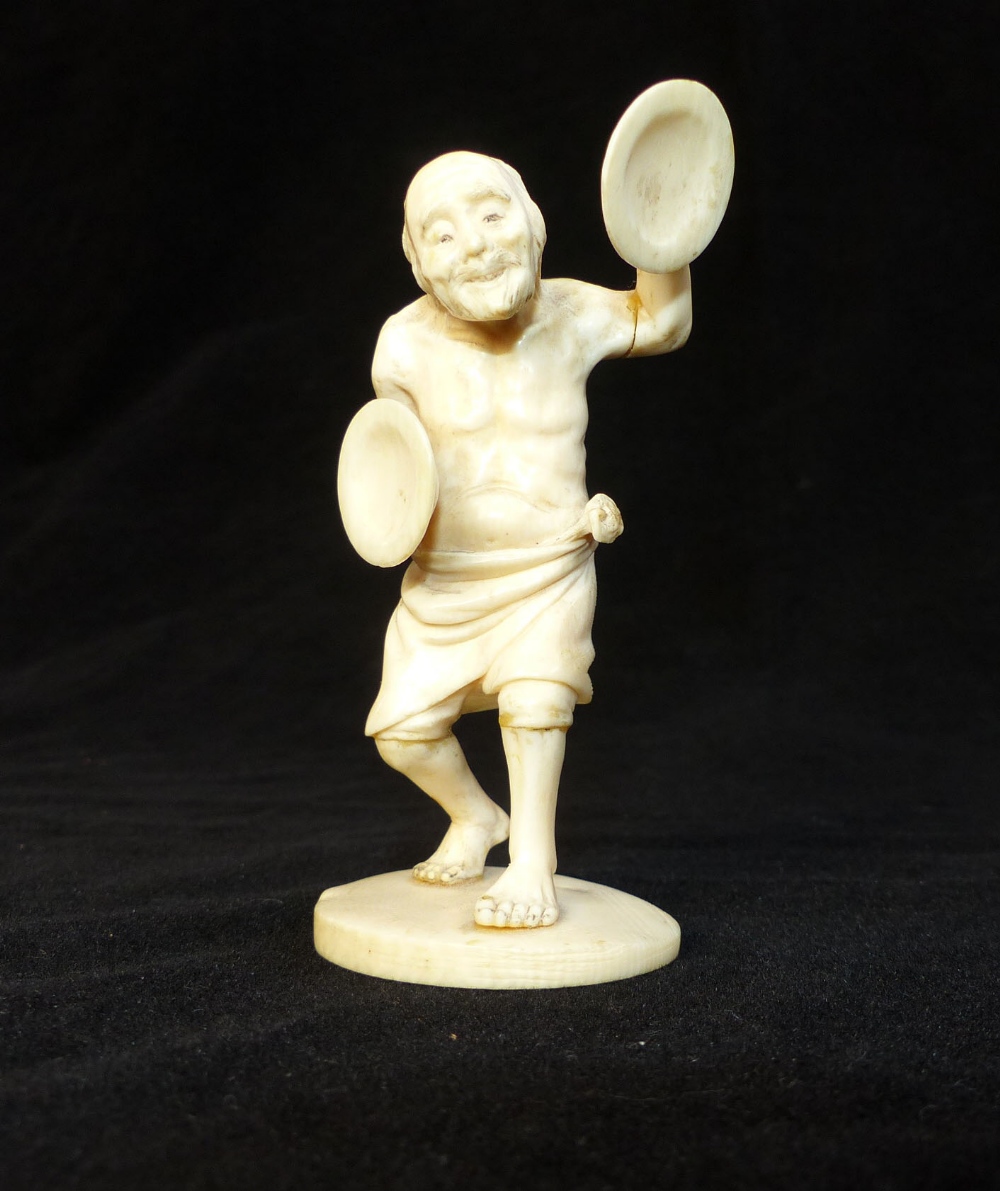 Carved antique ivory figure of a venerable cymbal player,