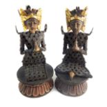 Pair of Balinese tribal figures seated on carved wooden lotus thrones,