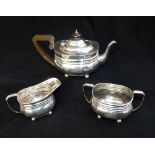 Edwardian silver three piece tea set, branded decoration with monogram set on ball feet, teapot,