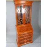 Reproduction yew bureau bookcase with blind fret pediment over two glazed doors,