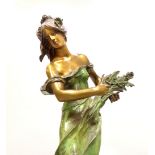 Art Nouveau style green pantinated bronze of a young woman holding a bouquet of flowers,