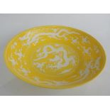 Chinese yellow ground dish, decorated in white with dragons chasing flaming pearls,