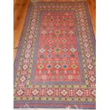 Red ground Shirvan rug, geometric and stylised floral design, fringed,