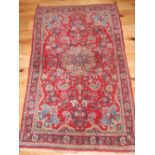 North West Persian red ground rug woven stylized flowers within a multi border 170 x 110 cms