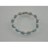 A silver and cubic zirconia blue topaz cluster bracelet