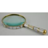 A large brass bound table magnifier set with mother of pearl