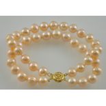 An 8-10mm natural pink pearl two row bracelet with a 14ct gold clasp