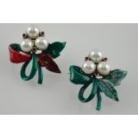 A pair of silver brooches with green leaves,