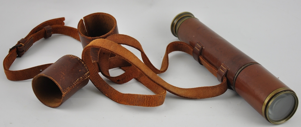 An early 20th Century lacquered brass 2 draw telescope with leather outer cover,