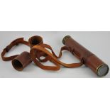 An early 20th Century lacquered brass 2 draw telescope with leather outer cover,