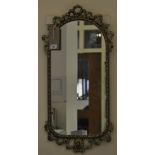 An early 20th Century gilt brass wall mirror, the glass with husk border, in ribbon-fold frame,