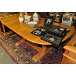 A reproduction oak twin pillar extending dining table on turned baluster legs,