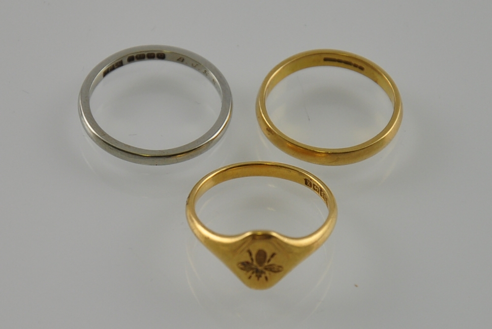 Two 18ct yellow and white gold bands together with an 18ct signet ring embossed with a bee, total 8.