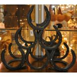 A cast iron six bottle horseshoe wine rack