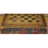 **WITHDRAWN**A 20th Century gilt tooled leather covered folding games box containing boxwood chess