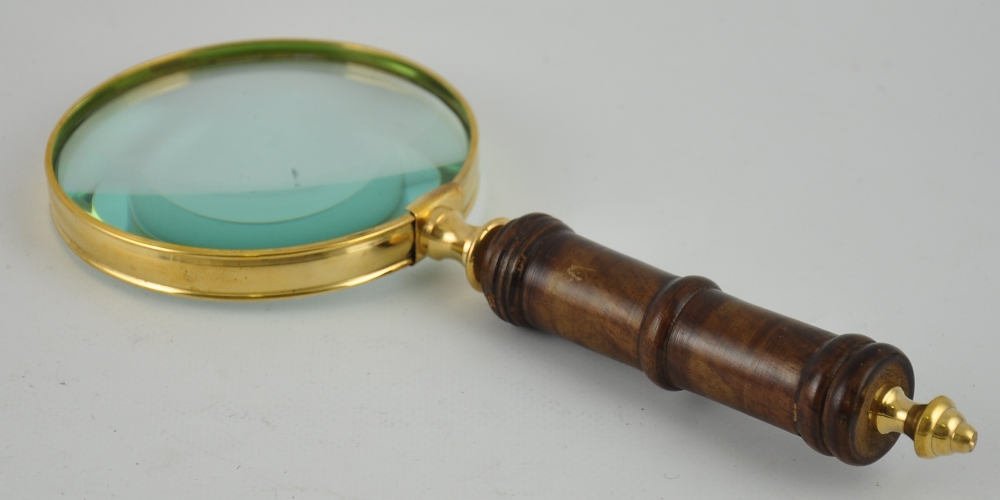 A brass bound table magnifier with a turned wooden handle