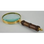 A brass bound table magnifier with a turned wooden handle