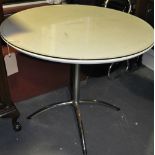 A white and chrome circular dining table with glass top