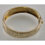 A silver gilt bangle with incised foliate decoration