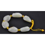 A Jade bracelet with six irregular beads in the form of laughing Buddhas