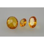 Three unmounted amber coloured stones