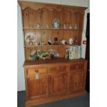 A Victorian style pine dresser with 2 tier rack over three drawers and panelled cupboards, W.