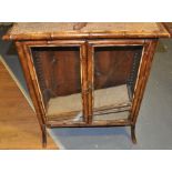 A late Victorian caned glazed bamboo two door bookcase,