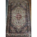 A Persian wool and silk hand woven rug on blue ground with floral motif,